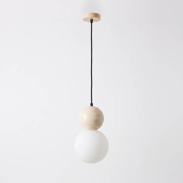 Siena travertine pendant light, a stone sphere above a frosted opal glass globe on a black cord, on a plain white background