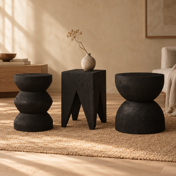 Nara charcoal wood stools in the stacked, square and hourglass shapes on a jute rug, vase shown for styling only