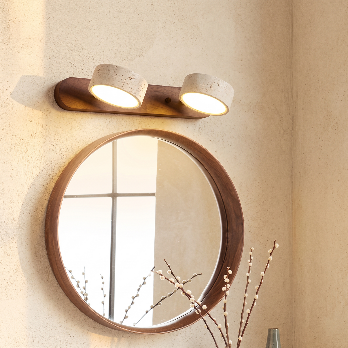 Trevi twin wall light in walnut tone, lit above a round wooden mirror