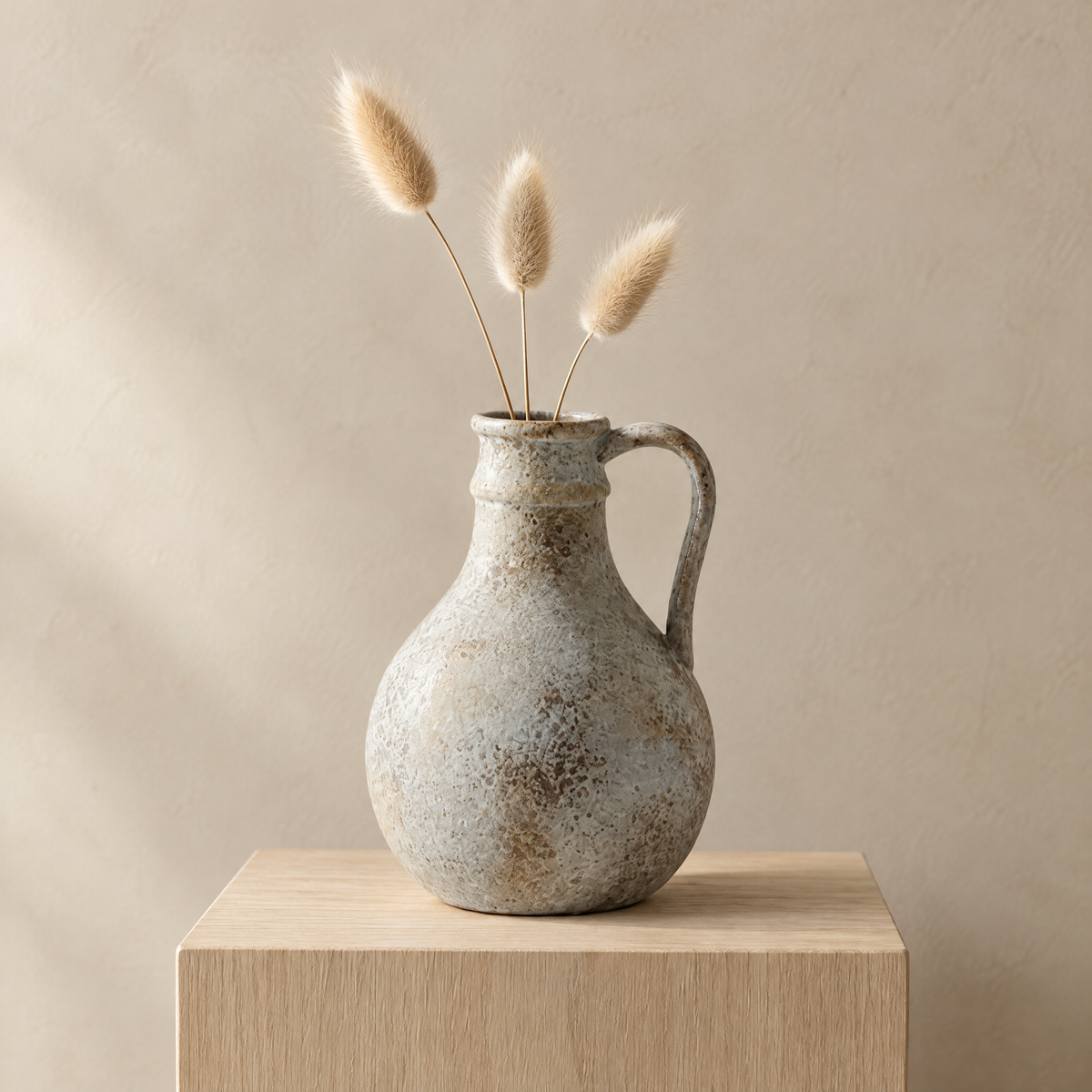 Round Bizen jug vase holding dried bunny tail grass on an oak plinth