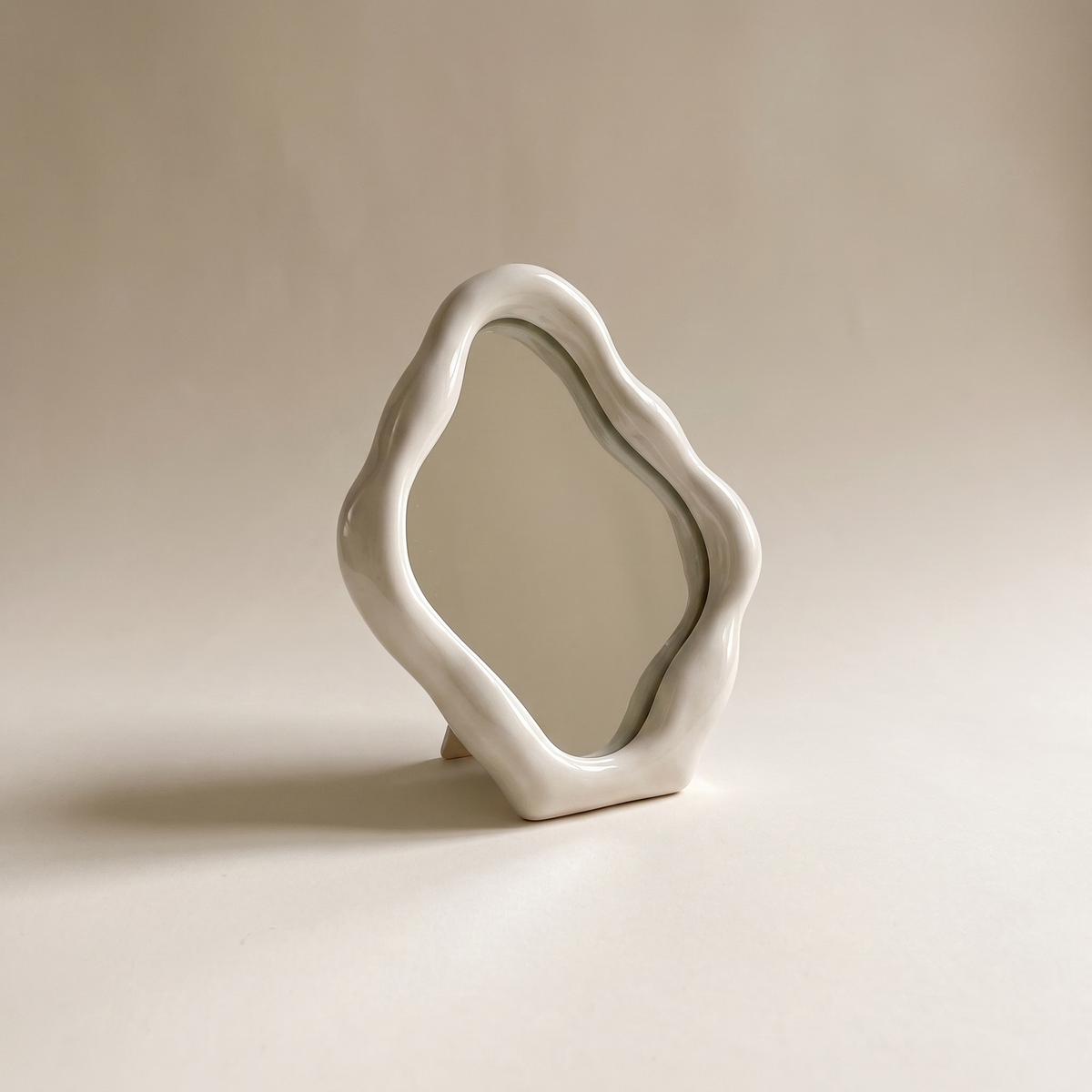 Shizuoka ceramic table mirror with an irregular organic frame, studio shot