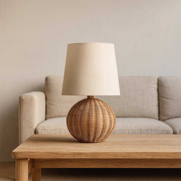 The Odense table lamp on a wooden table beside a linen sofa